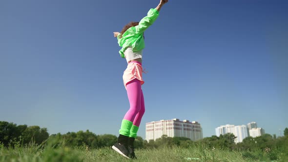Wide Shot Joyful Woman in Retro Clothes Jumping Spinning Dancing Outdoors in Sunshine alt