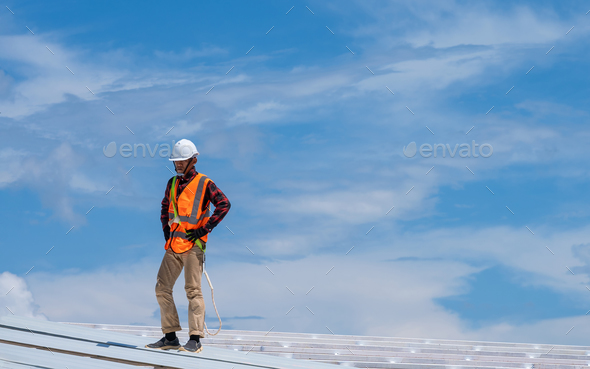 Construction worker wearing safety harness working at high level install  new roof Stock Photo by visootu2