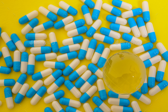 Medicine pills and a world globe represent different perspectives on global health