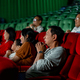 Wide shot of Asian man look scary or panic during watch movie with his family in cinema theater - PhotoDune Item for Sale