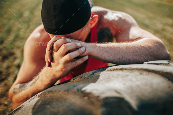 Outdoor Fitness Portrait of a Tired Muscular Man Leaning on Tire After Crossfit Training