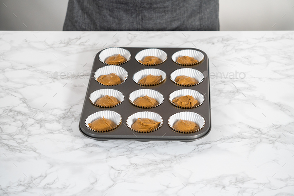 Scooping cupcake batter with a dough scoop into cupcake foil