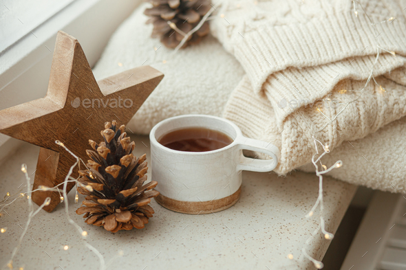 Cozy winter still life. Stylish cup of tea with cozy knitted sweater, pine  cone Stock Photo by Sonyachny