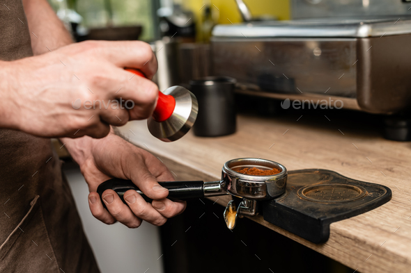 barista holding tamper near portafilter with grinded coffee, espresso, manual  press Stock Photo by LightFieldStudios