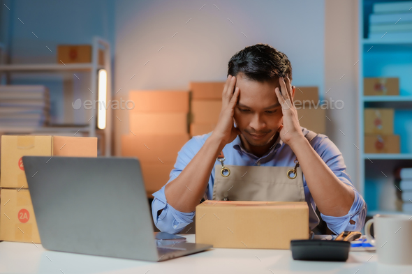 Asian male business owner stressed and uneasy surrounded by boxes. business bankruptcy concept.
