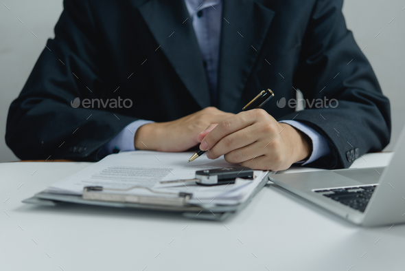 Man signing car insurance document car key on contract or agreement.