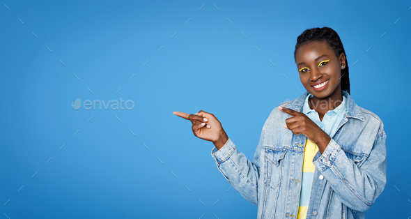Happy pretty young black woman 20s pointing at blank space Stock Photo ...