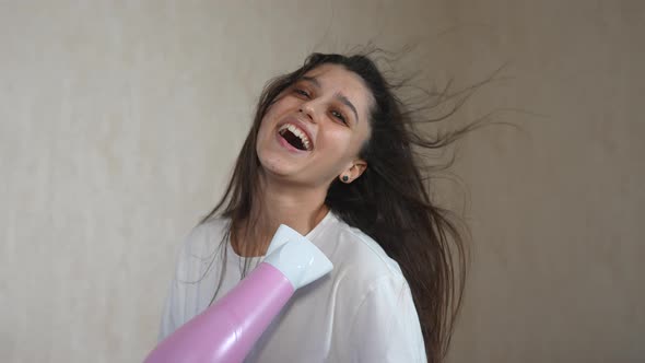 Female Drying Her Hair with Hairdrier Flying Hair