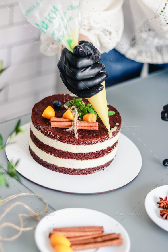 A Pastry Chef Decorates A Chocolate Naked Cake With Drips Of White Chocolate From A Pastry Bag