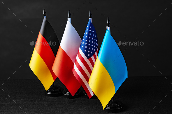 Four little flags of Germany, Ukraine, Poland and Usa on black background