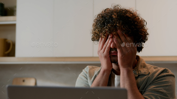 Close up Indian ill tired sleepy man with curly hair rubbing dry eyes Arabian exhausted sick guy
