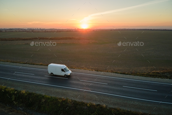 Aerial view of blurred fast moving cargo van driving on highway hauling goods