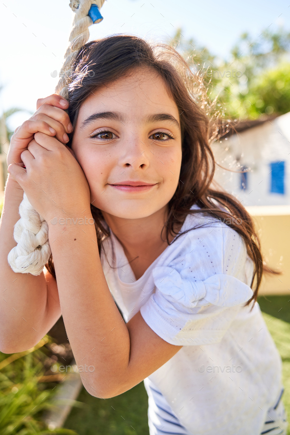 Smiling Cute Girl Looking At Camera And Standing Next To Rope Stock