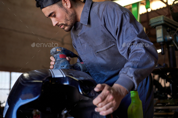 Professional mechanic repairing motorbike in garage