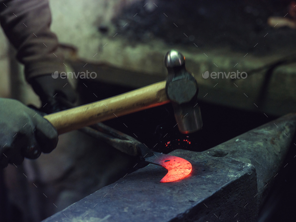 Crop farrier forging iron in workshop