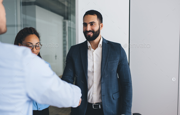 Happy businessman in formal clothes enjoying communication during brainstorming meeting in office