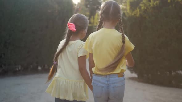 Little Girls Running in a Hedge Maze Two Sisters Kids Hold Hands and Run in Big Green Labyrinth in alt