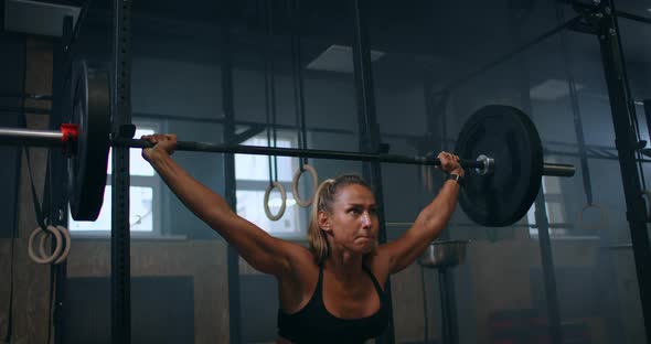 Slow Motion: Training Squats with Barbells Over Head. Muscular Female Lifting Barbell Over Head alt