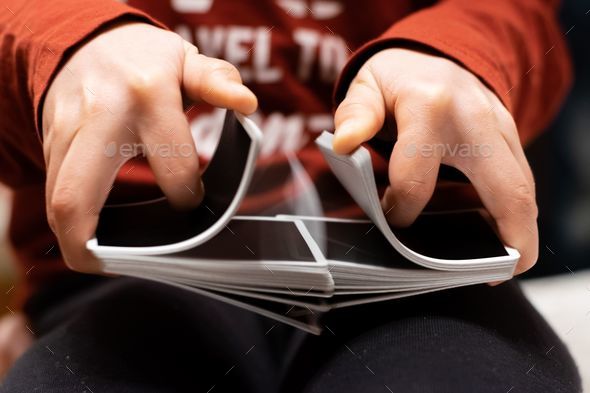 Closeup of person\'s hands shuffling the card deck on the table
