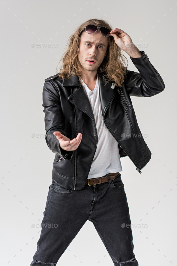 young handsome man in black leather jacket pointing isolated on