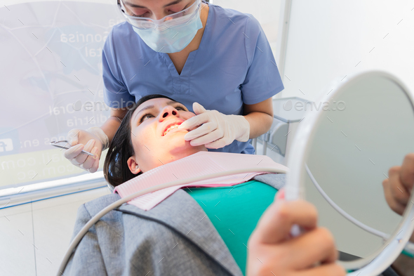 Young female dentist performed dental procedure to a female patient.
