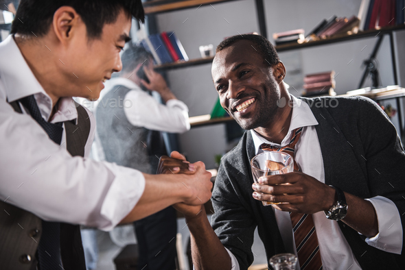 cheerful colleagues drinking alcohol while spending time together after work