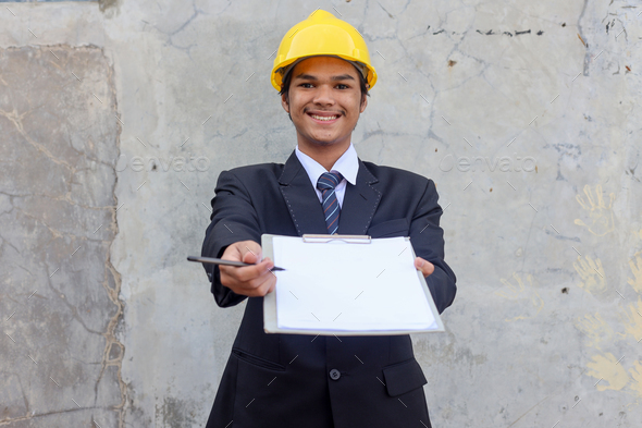 Young smiling Asian contractor manager giving document for signature