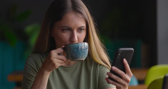 Close Up of Young Woman Having a Cup of Coffee or Tea in Cafe