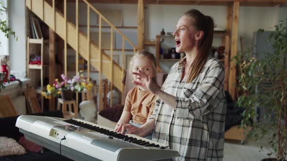 A Woman Shows the Girl the Basics of Singing and Uses the Piano