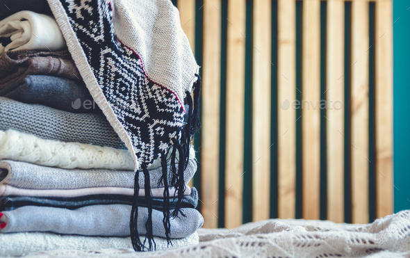 A stack of cozy warm winter clothes lies on the bed Stock Photo by  perfectlab