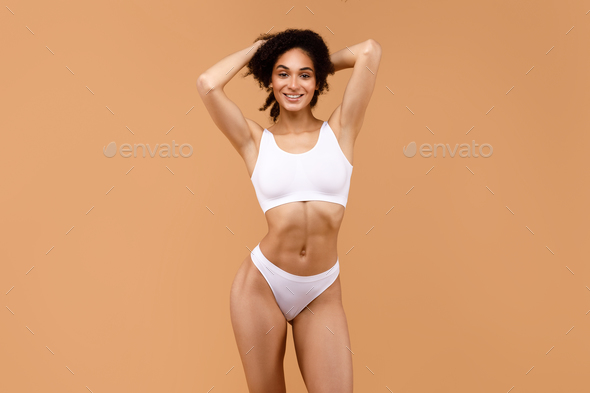 Posing for the camera. Young fitness woman with slim body type is
