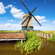 An old mill in the Netherlands. Historical building. A mill near a canal. Dutch architecture - PhotoDune Item for Sale