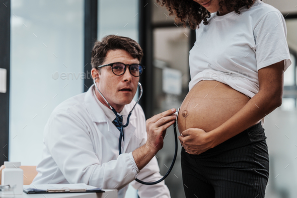 Male gynecologist doctor checking african american pregnant woman, Gynecology Consultation concept