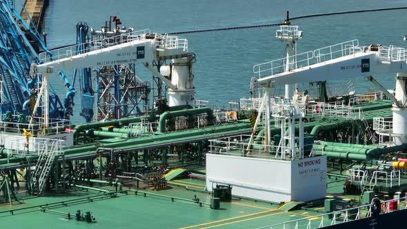Petroleum Tanker Vessel Offloading Fuel and Oil at a Refinery Port alt