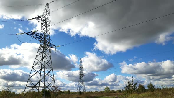 Power Lines And Blue Sky Time Lapse. High Voltage Electricity Transmission Pylon. alt