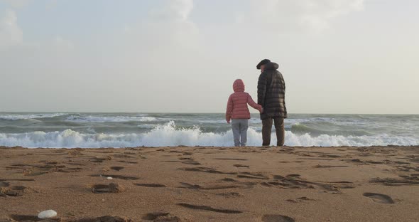 Young Girl Playing By the Sea with Her Grandfather