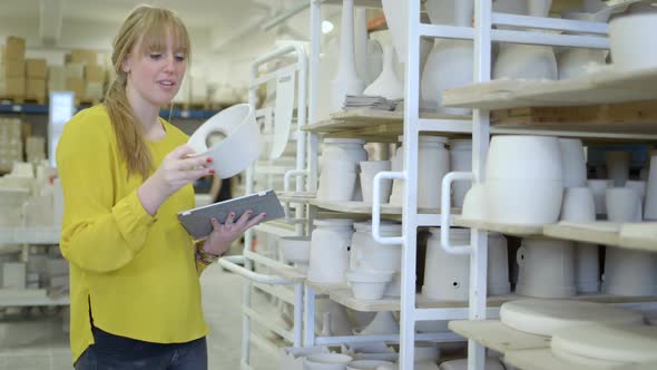 Male potter checking ceramic product in workshop