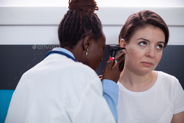 Doctor checking for patient ear symptoms