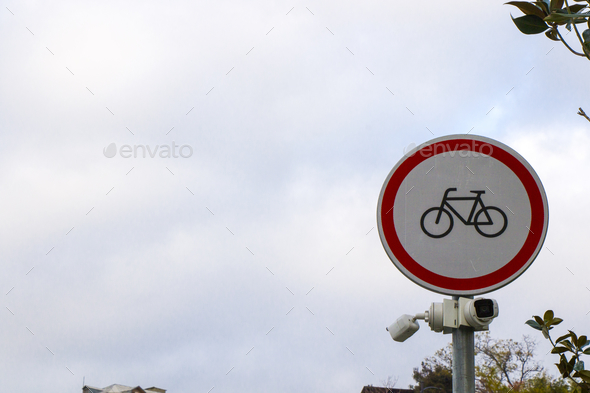 Closeup shot of a bicycle road sign and street cameras under on a gloomy dat