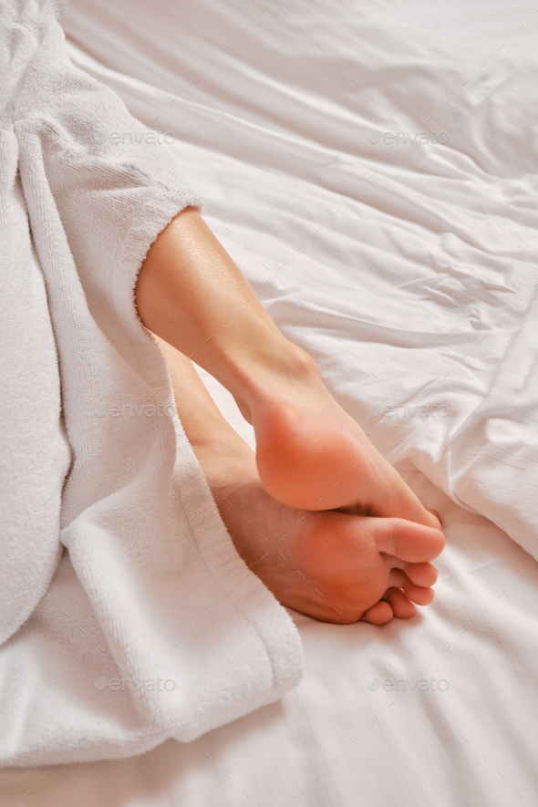 Close-up view of female sole and toes on bed