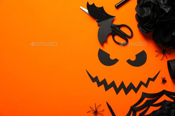 Scissors, paper bat, eyes and mouth on orange background, space