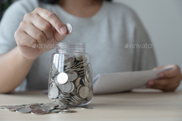Woman with bills and savings coin jar to pay monthly