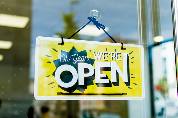 Selective focus of signage with a text We\'re Open through the glass door