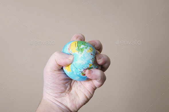 hand crushing globe of planet earth - ecocide or destruction of environment concept