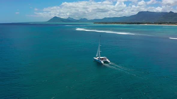 Sailing Catamaran in the Tropical Sea with Open Sails View From the Drone alt