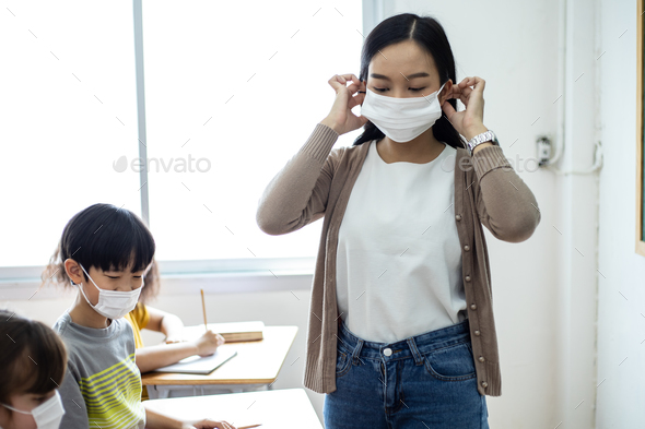 An Asian female teacher was wearing a face mask while teaching