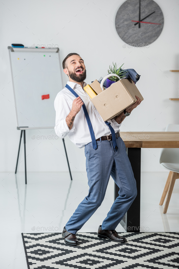 happy businessman with cardboard box in hands quitting job
