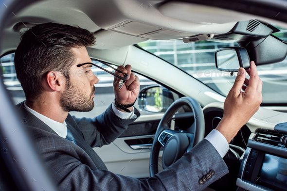 side view of businessman wearing eyeglasses while sitting in car Stock ...