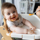 Happy baby boy eating first food pumpkin from spoon with mom at home - PhotoDune Item for Sale