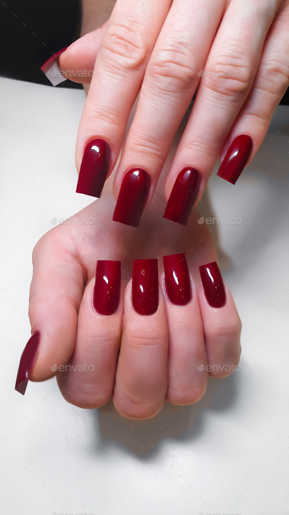 Acrylic nail extension, manicure, nail correction, hands in the foreground. Bright design.